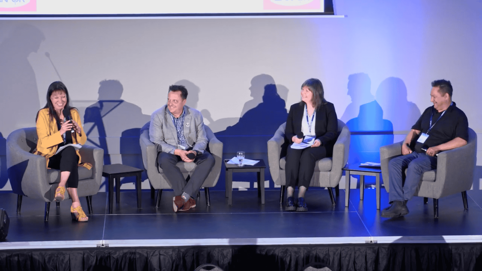 4 men and women sitting on a stage